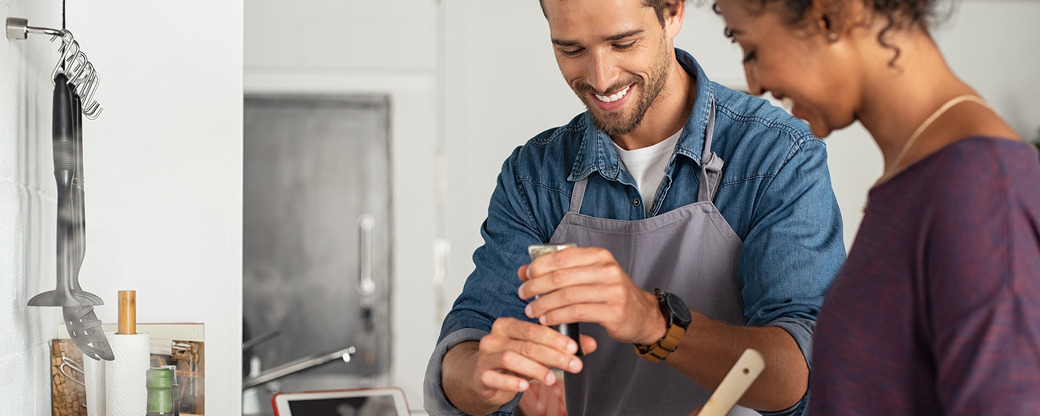 Heureux couple préparant la nourriture dans la cuisine.